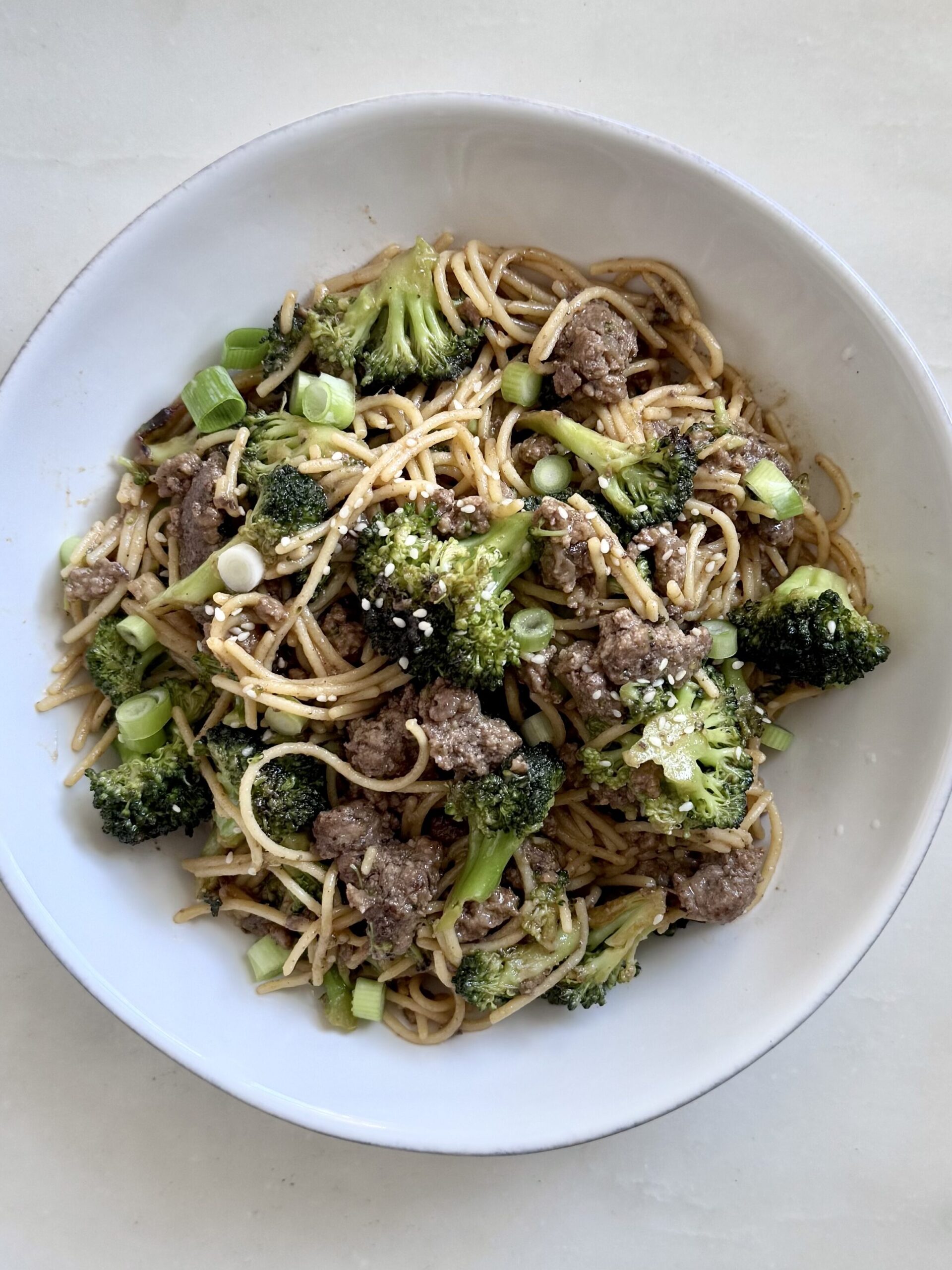 Photo of plated stir-fry with a fork, ready to eat on a cozy table setup