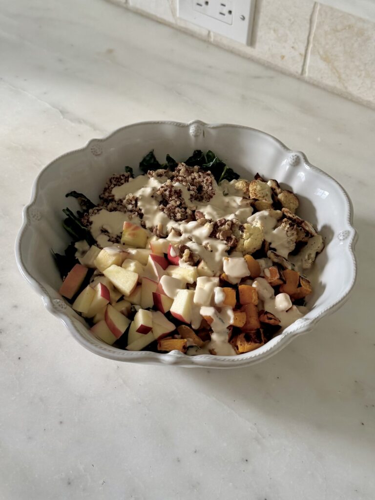 Creamy tahini dressing in a bowl with lemon juice and garlic drizzled over salad