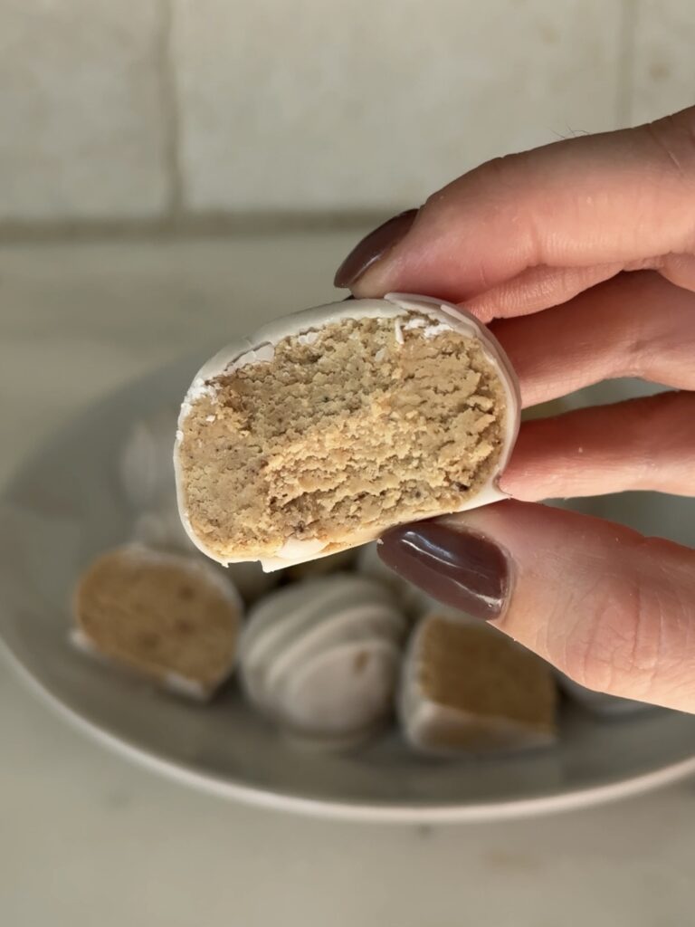 Close-up of white chocolate-coated chai protein cake balls showing smooth, creamy texture and spices