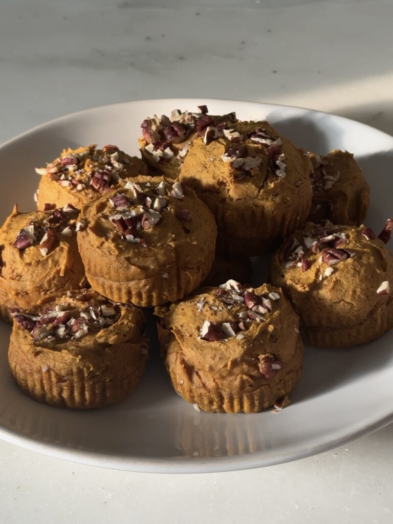Plate of healthy pumpkin protein muffins, gluten-free and dairy-free, topped with chopped pecans, ready to serve for breakfast or a snack