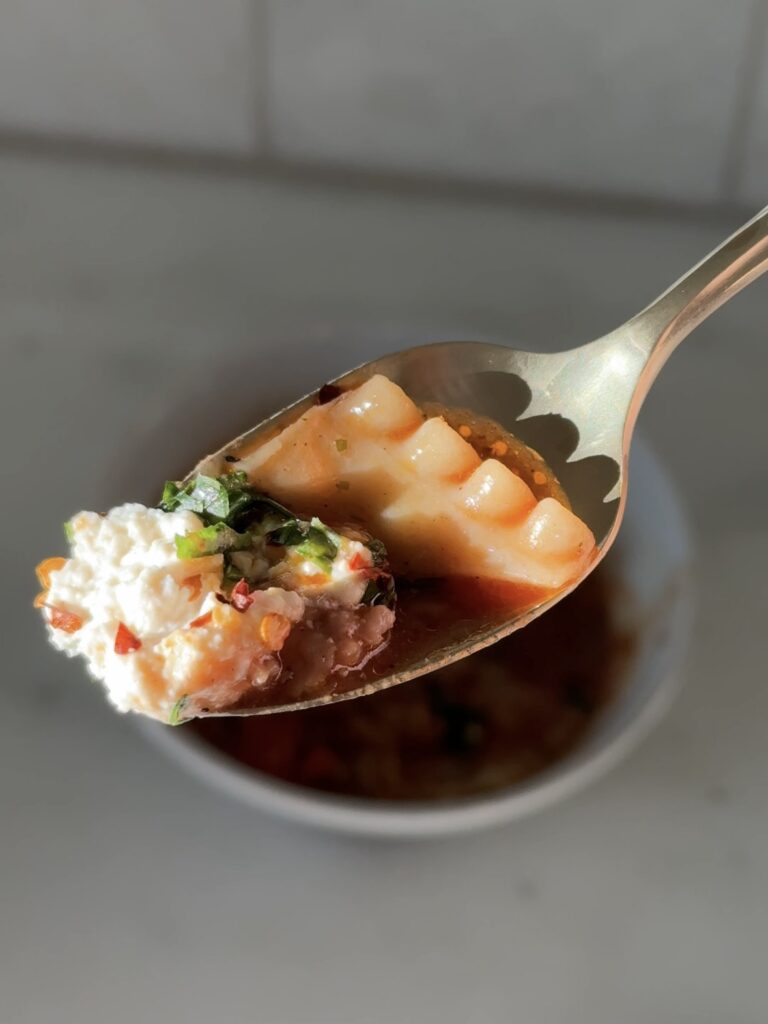 Close-up of a bite of one-pot lasagna soup showing noodles, meat, and creamy broth