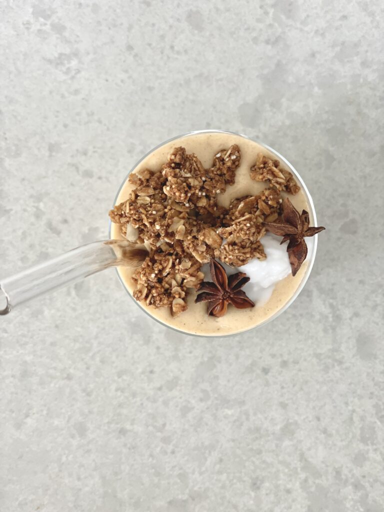 Pumpkin pie smoothie topped with cinnamon, granola and unsweetened coconut yogurt