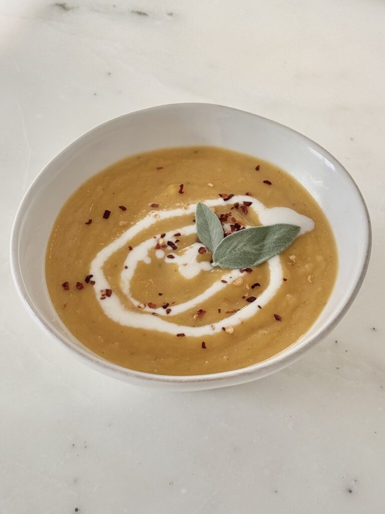 Bowl of creamy Sage Butternut Squash Soup topped with toasted sage and pumpkin seeds