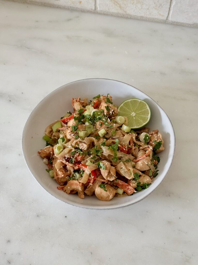 Bowl of Tahini Chicken Pad Thai with Miracle Noodles, red bell peppers, and shredded carrots