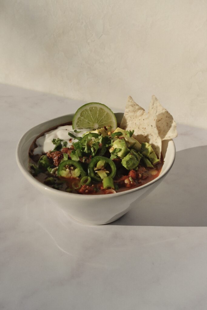 Cozy homemade beef chili served in a bowl with classic toppings.