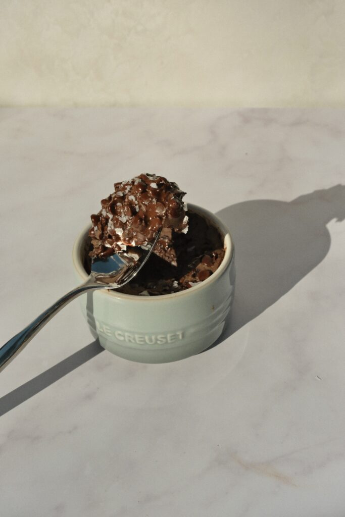 Healthy protein brownie bite on a spoon highlighting soft, fudgy texture of a single-serve microwave dessert