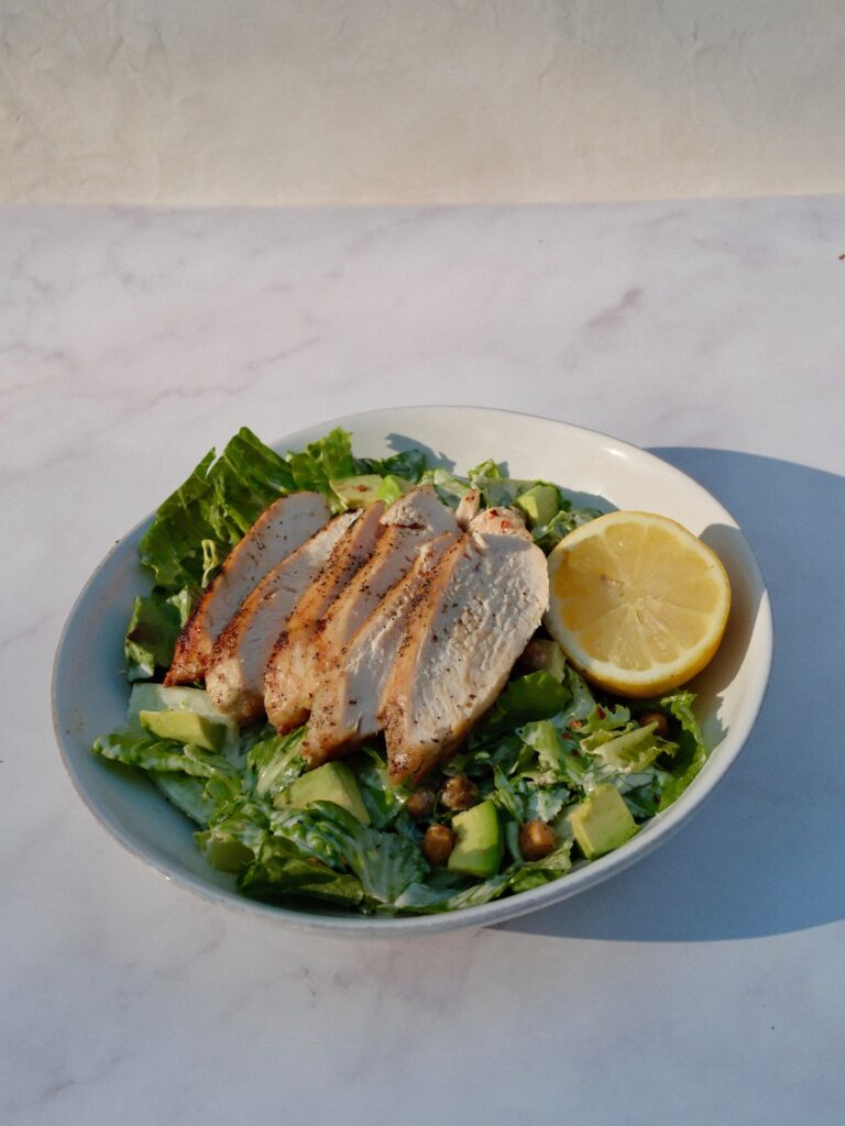 full finished chicken Caesar salad with crispy chickpeas and sliced chicken